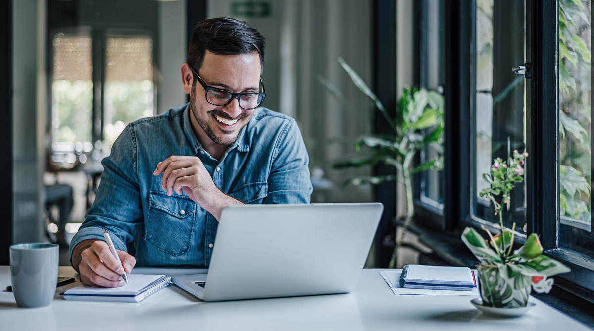 man smiling at laptop dentist web design working with a professional designer