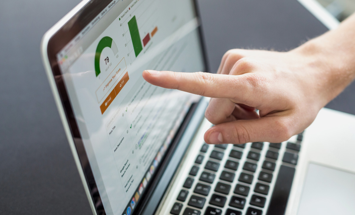 pointing at laptop screen crafting a message with strategies of marketing