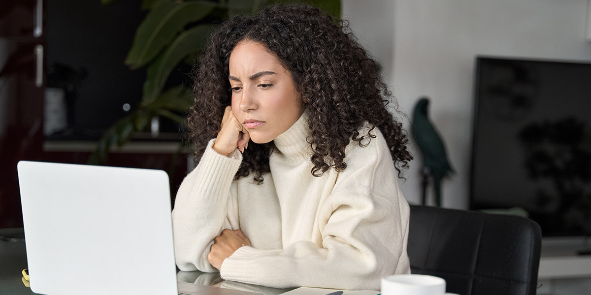 Woman looking at laptop unhappy why dentist websites fail