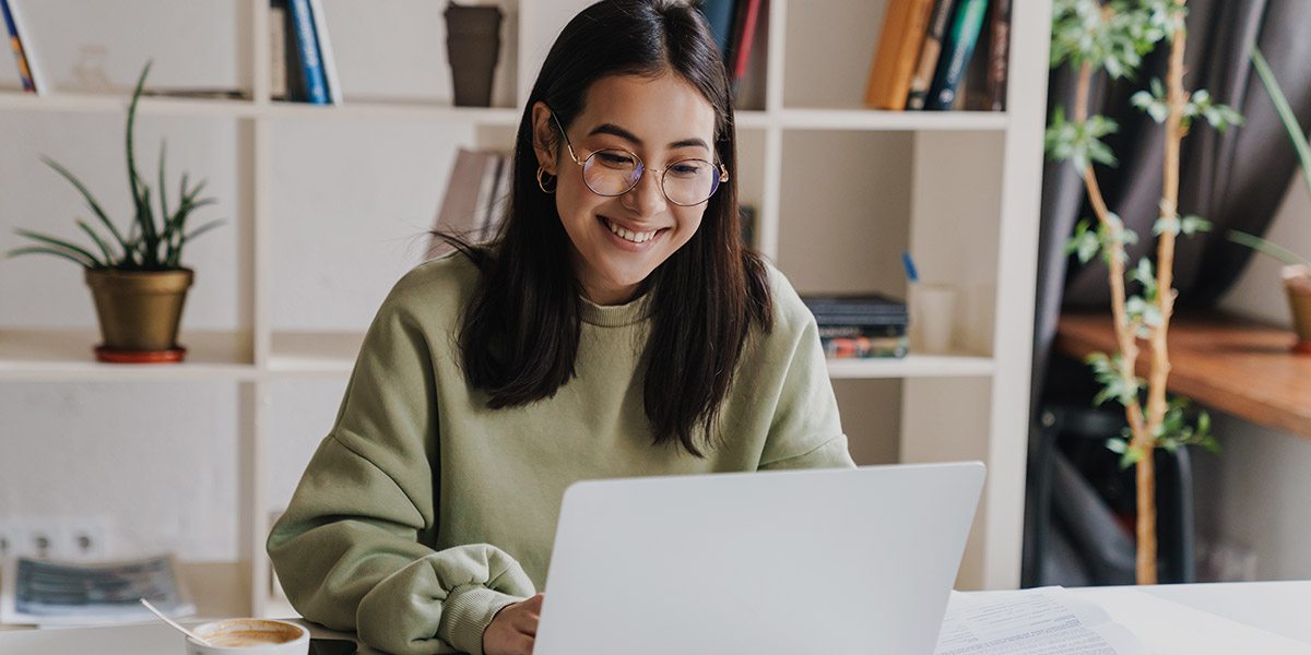 Woman smiling at laptop screen dental website CTA