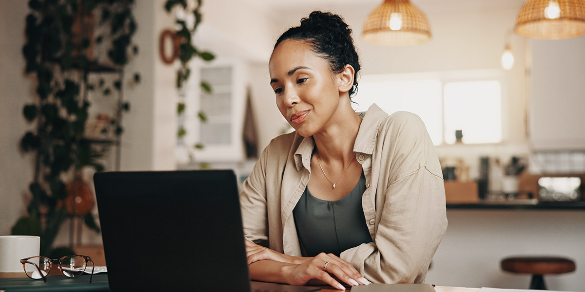Woman looking at laptop with a smile for dental website authority